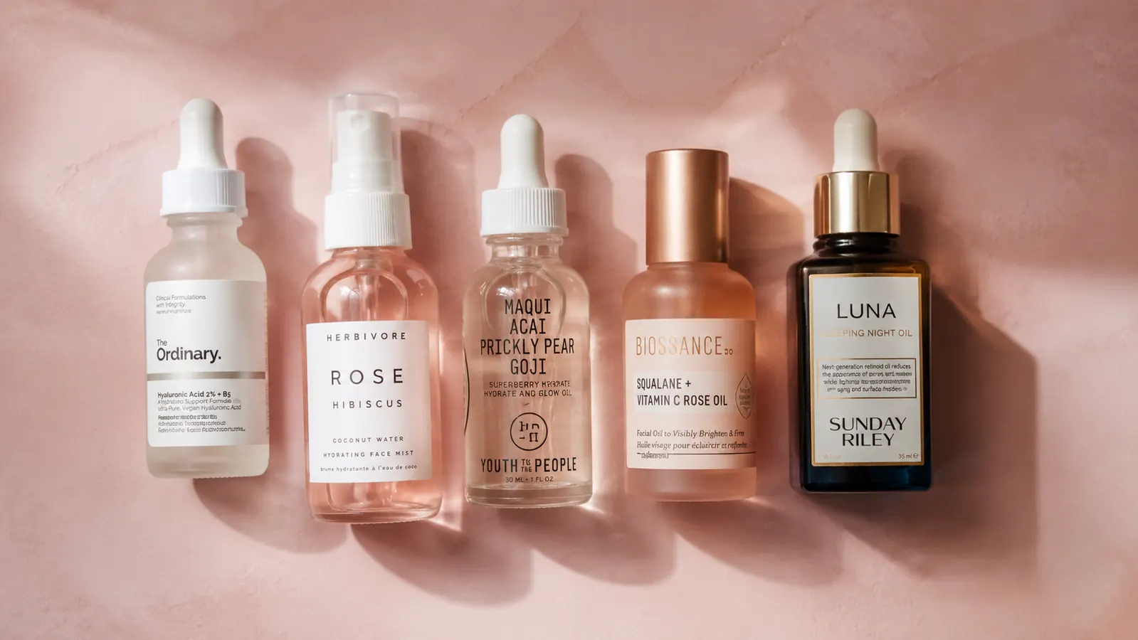 Flat lay of a full PM skincare routine lineup including snail mucin serum, PDRN serum, and moisturizer on a pale pink surface